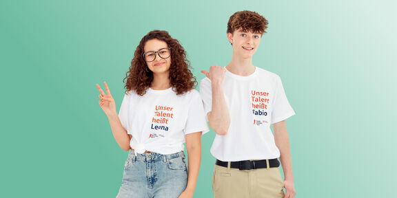 Foto von zwei Lehrlingen mit FSW T-Shirts vor grünem Hintergrund.